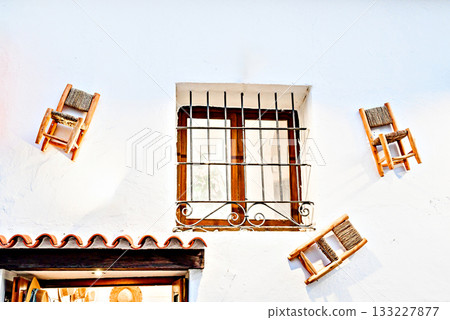 Rustic window with decorative chairs against a white wall. Altea, Alicante Rustic window with decorative chairs against a white wall. Altea, Alicante 133227877