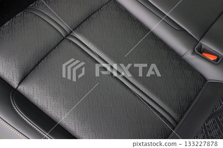 An original air vent pattern on a black leather seat in a premium car    133227878