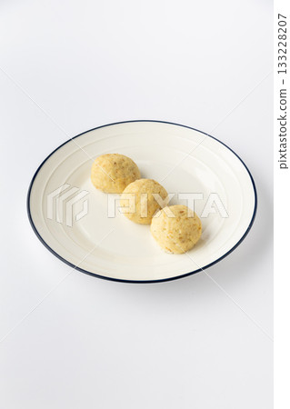 Three potato dumplings on a plate, studio shot on white background 133228207