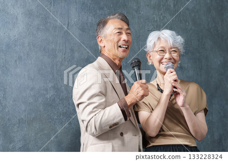 老年男女在卡拉OK台上拿著麥克風唱歌 133228324