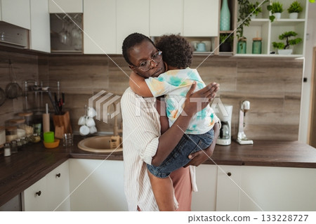 Mother hugging son in a kitchen offering comfort 133228727