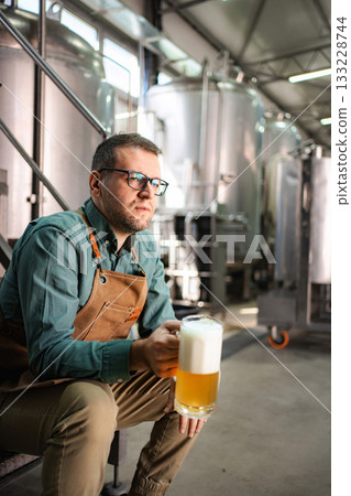 Man brewer tasting craft beer in modern brewery Man brewer tasting craft beer in modern brewery 133228744