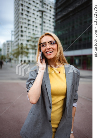 Young businesswoman talking on smartphone in urban setting Young businesswoman talking on smartphone in urban setting 133228758