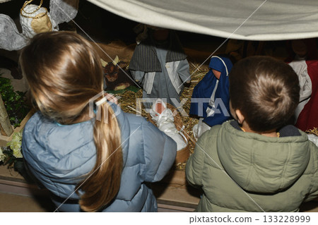 A child praying near a Christmas nativity scene with baby Jesus Creche Figurines 133228999