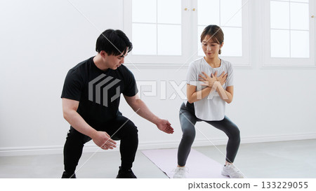 年輕女子正在接受私人教練的訓練 年輕女子正在接受私人教練的訓練 133229055