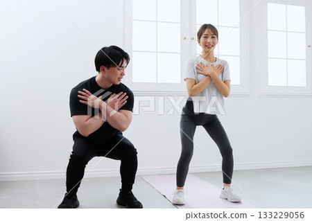 Young woman receiving training from a personal trainer Young woman receiving training from a personal trainer 133229056