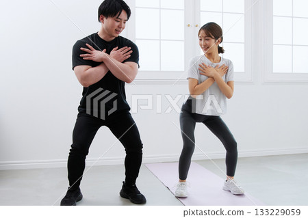 Young woman receiving training from a personal trainer 133229059