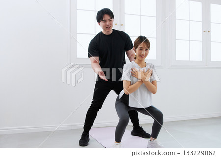 年輕女子正在接受私人教練的訓練 年輕女子正在接受私人教練的訓練 133229062