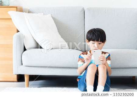 小學生在客廳玩智慧型手機 133230200