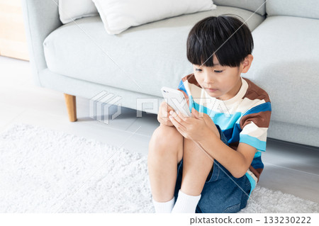小學生在客廳玩智慧型手機 133230222