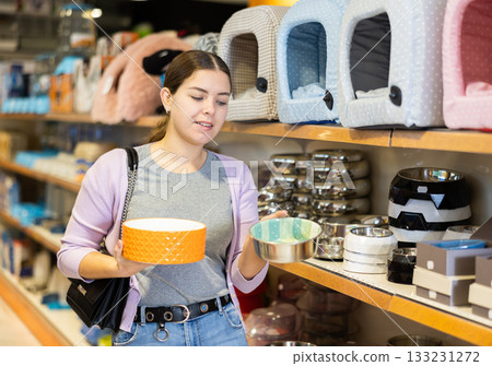 Young woman choosing bowl for puppy in pet supplies store Young woman choosing bowl for puppy in pet supplies store 133231272
