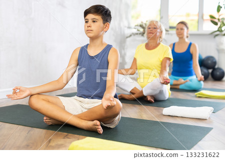 Group of people generation on mats doing yoga exercise lord of fishes pose. Group of people generation on mats doing yoga exercise lord of fishes pose. 133231622
