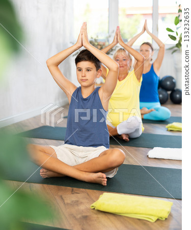 Group of people generation on mats doing yoga exercise lord of fishes pose. Group of people generation on mats doing yoga exercise lord of fishes pose. 133232635