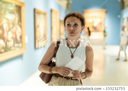 Woman looks at hall of paintings and sculptures Woman looks at hall of paintings and sculptures 133232753