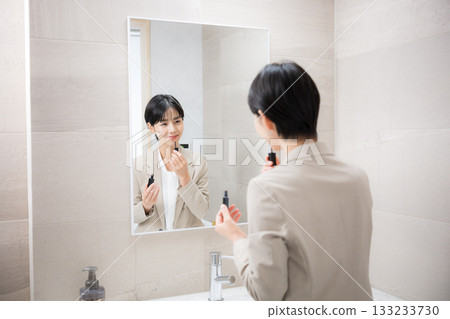 Image of applying lipstick or touching up makeup when preparing for work Image of applying lipstick or touching up makeup when preparing for work 133233730
