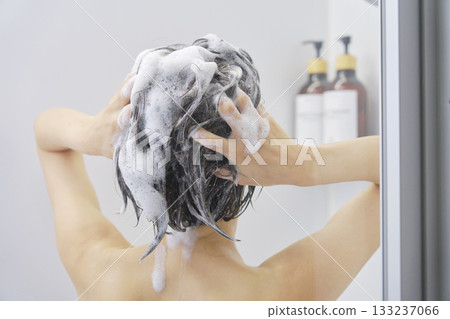 Woman washing her hair in the bathroom, back view 133237066