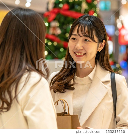 A woman in a warm moment with her friends smiling in the Christmas town 133237330