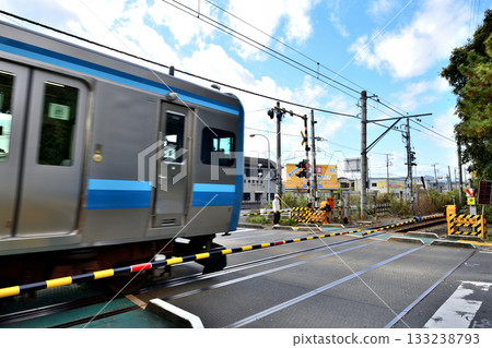 A Sagami Line train passing through Samukawa Daimon crossing and a man waiting for the train to pass 133238793