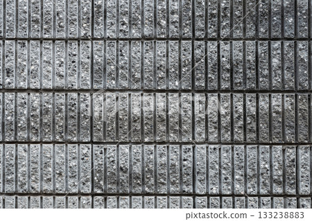 Weathered and aged texture: close-up of a concrete wall with crisscrossing cuts Weathered and aged texture: close-up of a concrete wall with crisscrossing cuts 133238883