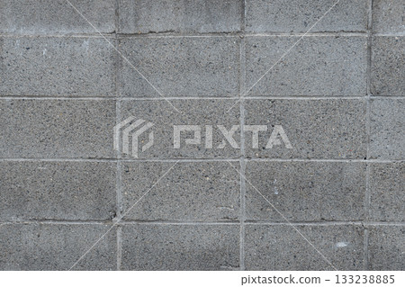 Weathered and aged texture: close-up of a slightly deteriorated concrete block wall Weathered and aged texture: close-up of a slightly deteriorated concrete block wall 133238885