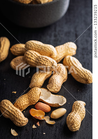 Peanuts in shell. Groundnuts on black table. 133239215