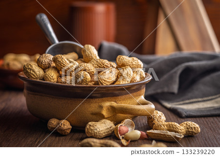 Peanuts in shell. Groundnuts  in bowl on wooden table. 133239220