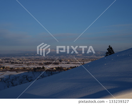 A view of Hirosaki City and the Hakkoda mountain range in the distance from the snowy mountain A view of Hirosaki City and the Hakkoda mountain range in the distance from the snowy mountain 133239327