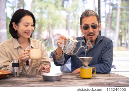 在山梨縣八岳的露營地,一家人正在享受烹飪的樂趣。 在山梨縣八岳的露營地,一家人正在享受烹飪的樂趣。 133240000