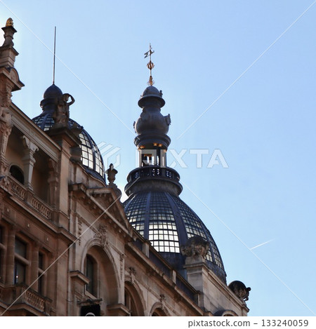 Historic building with intricate architectural details, featuring ornamental glass domes and a striking cupola topped with a weathervane. Antwerp, Belgium Historic building with intricate architectural details, featuring ornamental glass domes and a striking cupola topped with a weathervane. Antwerp, Belgium 133240059