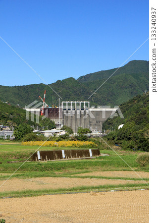 A scene of dam construction underway against the backdrop of a clear, blue autumn sky 133240937