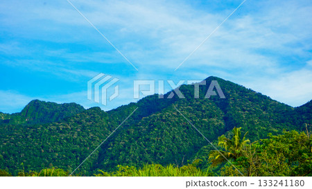 beautiful view of mountains with white clouds and clear blue sky in the background beautiful view of mountains with white clouds and clear blue sky in the background 133241180