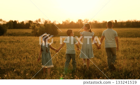 Happy children run towards sunset, girl boy holding hands run play, fun summer holidays, children recreation, kids friendship love, tender youthful companionship, wide open space, childhood love 133241519