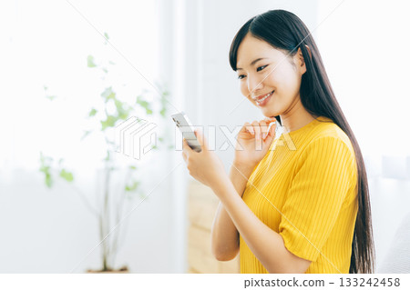 觀看在沙發的一位小姐一個智能手機 133242458