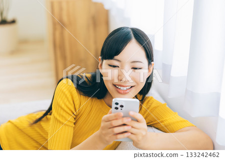 觀看在沙發的一位小姐一個智能手機 133242462