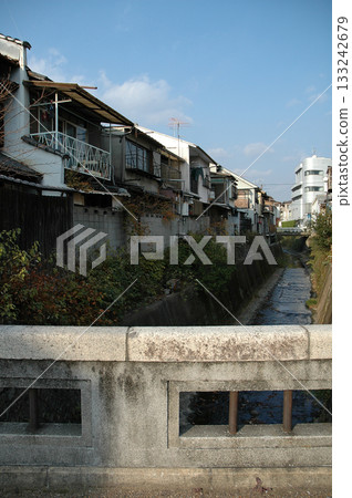 Old houses / A nostalgic scene at dusk in a town lined with old Japanese houses along an irrigation canal 133242679