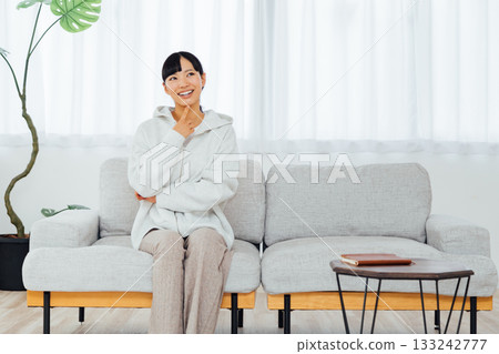 一位女士在房間裡放鬆身心,思考著令人興奮的計畫。 一位女士在房間裡放鬆身心,思考著令人興奮的計畫。 133242777