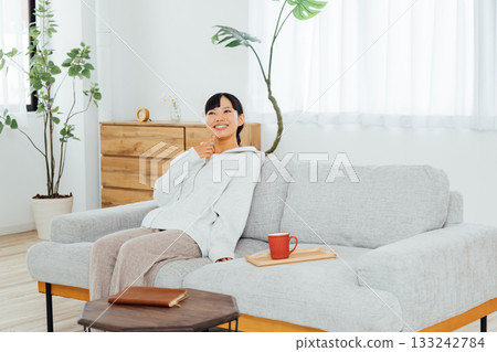 A woman relaxing in her room and thinking about exciting plans A woman relaxing in her room and thinking about exciting plans 133242784