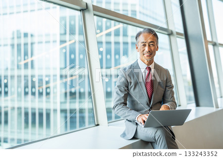Senior businessman operating a laptop Senior businessman operating a laptop 133243352