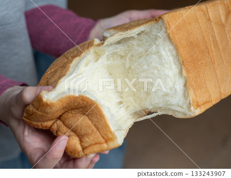 A person holding soft bread A person holding soft bread 133243907