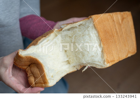 A person holding soft bread A person holding soft bread 133243941