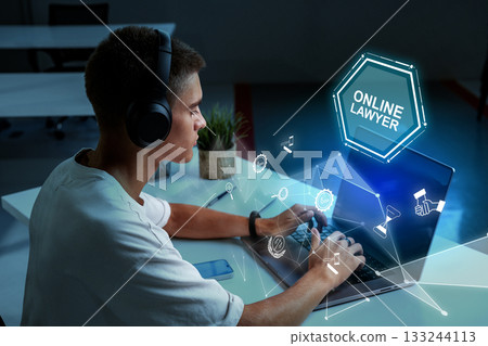 Young man working as an online lawyer at home during evening hours Young man working as an online lawyer at home during evening hours 133244113