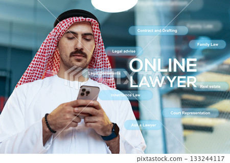 Online lawyer checking messages while dressed in traditional attire in a modern office 133244117