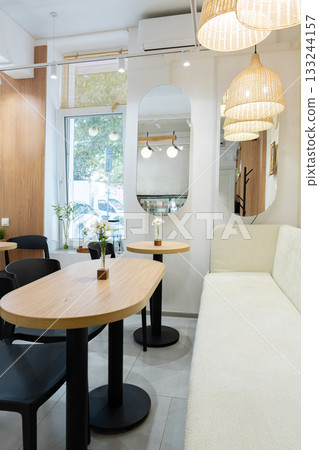 Cozy cafe interior with soft lighting and modern furniture in the afternoon Cozy cafe interior with soft lighting and modern furniture in the afternoon 133244157
