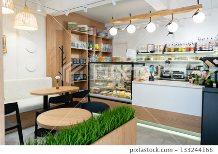 Cozy cafe interior with displays of food and drinks during daytime visit Cozy cafe interior with displays of food and drinks during daytime visit 133244168