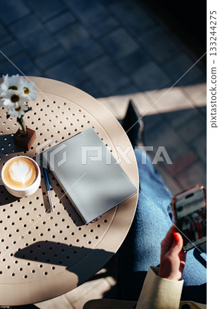 Calm morning at a cafe with coffee, notebook, and phone in hand Calm morning at a cafe with coffee, notebook, and phone in hand 133244275