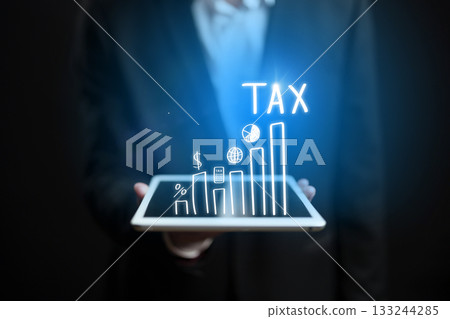Businessman using tablet to analyze tax data in a professional setting Businessman using tablet to analyze tax data in a professional setting 133244285