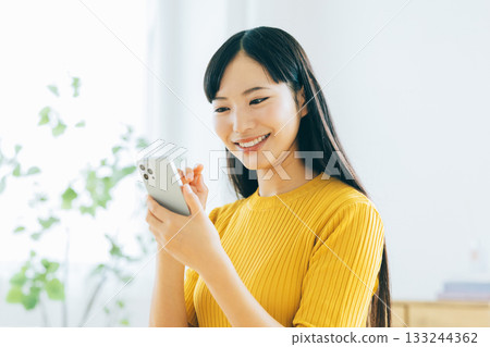 年輕女子在客廳看智慧型手機 133244362