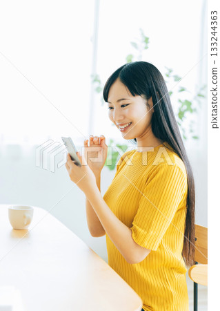 年輕女子在客廳看智慧型手機 133244363