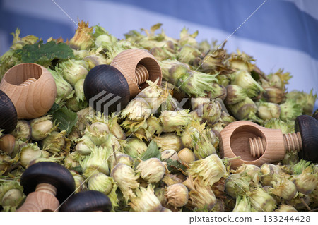 Hazelnuts and Wooden Nutcrackers Piled High in Rustic Autumn Display 133244428