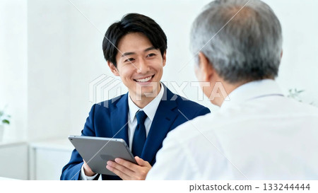 Smiling male staff member and senior man consulting 133244444